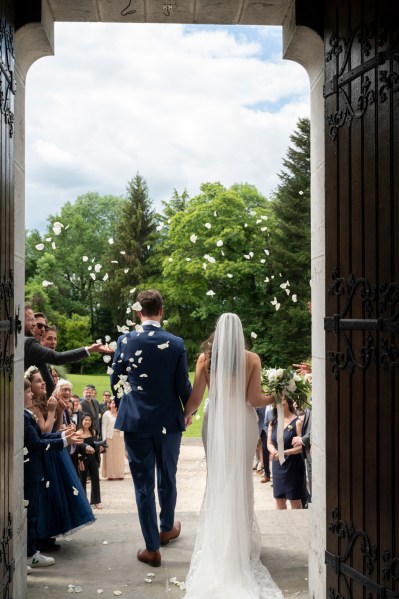 Bride and groom exit the church guests outside throwing confetti on them